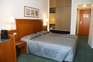 a hotel room with a bed and a television at Adrian Hotel in Athens