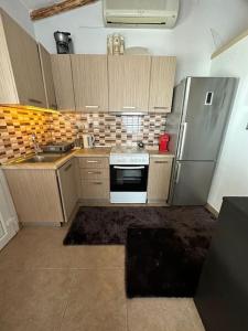 a small kitchen with a refrigerator and a stove at 7ο_seahome in Alexandroupoli