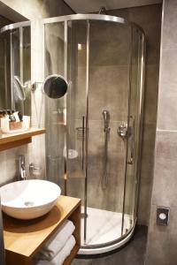uma casa de banho com um chuveiro, um lavatório e um WC. em Adrian Hotel em Atenas mais 29 fotografias