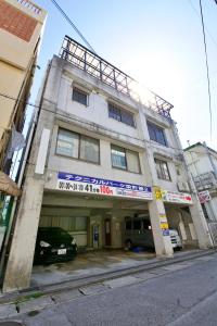 a building with a car parked in front of it at ゼネラルハイツ栄町3,4F in Asato