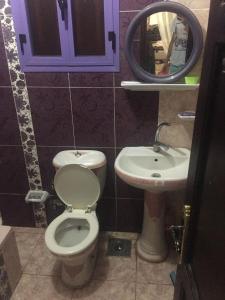 łazienka z toaletą i umywalką w obiekcie Super Lux w mieście ‘Ezbet el-Auqât