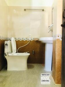 a bathroom with a toilet and a sink at Trinetra Guest House in Rishīkesh
