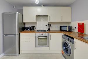 a kitchen with white cabinets and a stainless steel refrigerator at Tudor Close in Sheffield