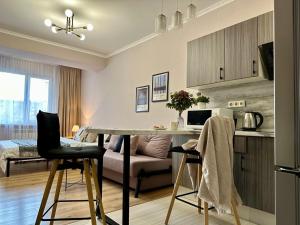 a kitchen and living room with a table and chairs at Студия МЕРЕНГА в центре Алматы in Almaty