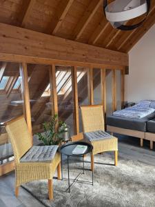 a room with two chairs and a table and a bed at Ferienwohnung am Wald-und Wiesenkorb in Kell