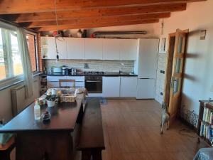 eine Küche mit weißen Schränken und einer hölzernen Arbeitsplatte in der Unterkunft FUSNAR in Aquilinia