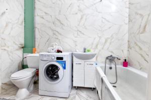 a bathroom with a washing machine and a sink at Просторные апартаменты в ЖК 7 бочек in Taldykolʼ