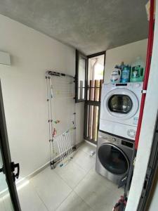 a laundry room with a washing machine and a refrigerator at LUX APPARTMENT GOLF DE MONT CHOISY in Mont Choisy