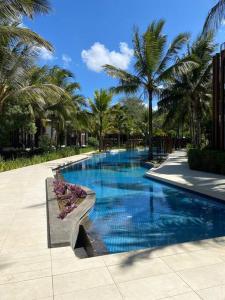a swimming pool with palm trees in a resort at LUX APPARTMENT GOLF DE MONT CHOISY in Mont Choisy