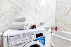 a washing machine with towels on top of it in a bathroom at Просторные апартаменты в ЖК 7 бочек in Taldykolʼ