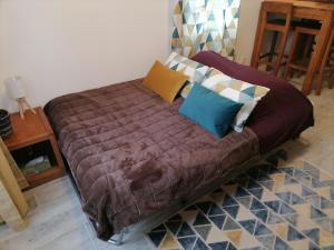Bett mit Kissen darauf in einem Zimmer in der Unterkunft Studio 2 à 4 personnes in Dompierre-sur-Mer