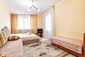 a hotel room with two beds and a window at Просторные апартаменты в ЖК 7 бочек in Taldykolʼ