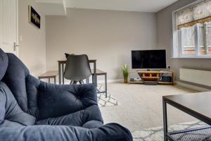 a living room with a blue couch and a television at Tudor Close in Sheffield