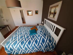 una camera con un letto e un piumone blu e bianco di FUSNAR a Aquilinia