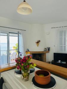 a living room with two plates and flowers on a table at 2 Ambelia paradise in Megalochori