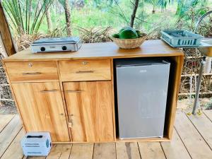a wooden counter with a refrigerator and a basket of fruit at Glamping Lakeview Ouidah in Gakpé