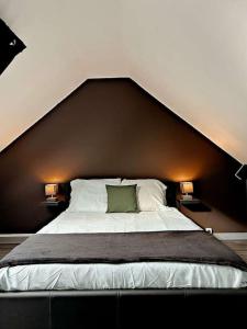a bedroom with a large bed with two lamps at Cosy Dunkerquois in Dunkerque
