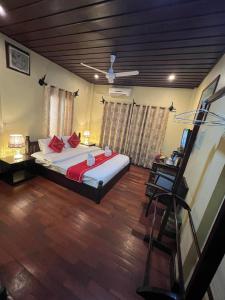 a bedroom with a large bed with red pillows at Villa Champa in Luang Prabang