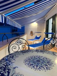 Donna Luisa Suites 19 Amalfi view - free parking في Pontone: غرفة نوم بسرير وكراسي ذات لون ازرق وبيض