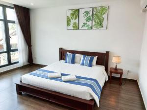 1 dormitorio con 1 cama grande con almohadas azules y blancas en VANG VIENG TOPVIEW HOTEL, en Vang Vieng