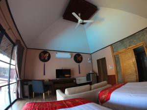 a hotel room with a bed and a living room at Naga Tara Boutique Resort in Phayao