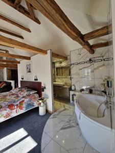 La salle de bains principale est pourvue d'une baignoire et d'un lit. dans l'établissement Le mas ROLLAND - Piscine & SPA - MILLAU-GORGES du TARN, à Compeyre