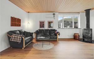 sala de estar con sofá de cuero negro y fogones en Nice Home In Aabenraa With 2 Bedrooms And Wifi, en Aabenraa