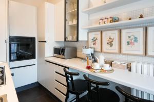 a kitchen with a counter with chairs and a microwave at B&b Piazzetta in Fermo
