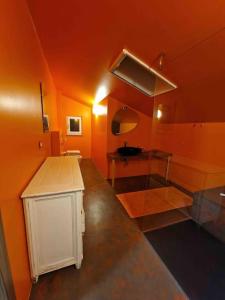 - une cuisine avec des murs orange et un comptoir dans une pièce dans l'établissement Nel verde Ligure , “non solo mare” outdoor e relax, à Calice Ligure