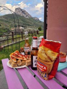 une table avec un sandwich, des chips et de la bière dans l'établissement Nel verde Ligure , “non solo mare” outdoor e relax, à Calice Ligure
