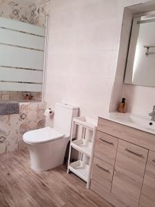 a white bathroom with a toilet and a sink at Casa Quimeres in Denia