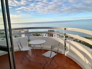 einen Balkon mit einem Tisch, Stühlen und Meerblick in der Unterkunft Ma vue mer en Algarve in Portimão