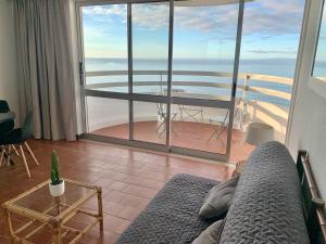 ein Wohnzimmer mit einem Sofa und Meerblick in der Unterkunft Ma vue mer en Algarve in Portimão
