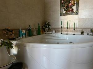 La Frasca في Coltaro: حوض استحمام أبيض في حمام به شموع خضراء