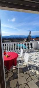 czerwony stół i dwa białe krzesła na patio w obiekcie Apartments Berny w mieście Sveti Vid-Miholjice