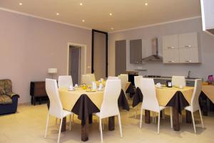 a dining room with yellow tables and white chairs at Pozzillo San Rocco in Arnesano