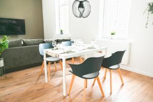 ein Esszimmer mit einem weißen Tisch und Stühlen in der Unterkunft 80qm Apartment in Krefeld zentral gelegen mit hohen Decken - BEUYS Apartments - Krefeld in Krefeld