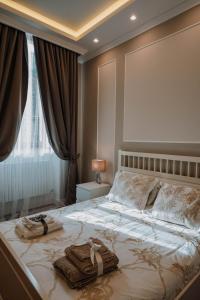 una camera da letto con un grande letto con asciugamani di B&b Piazzetta a Fermo