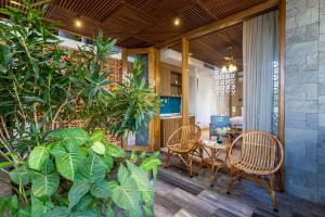 eine Terrasse mit einem Tisch, Stühlen und Pflanzen in der Unterkunft Daisy Boutique Hotel in Đà Nẵng
