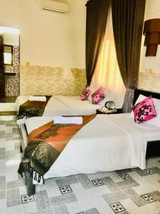 two beds in a hotel room withskirts at Siemreap Nitnit Boutique in Phumĭ Kngan Pông