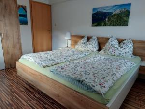 een slaapkamer met een groot bed met een houten hoofdeinde bij Ferienwohnung Werner Pucher OG in Altaussee