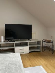 - un salon avec une télévision à écran plat dans un centre de divertissement dans l'établissement StayEasy Apartments Graz A6, à Graz