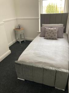 1 dormitorio con 1 cama grande y cabecero en Cheshire Home Stays, en Church Coppenhall