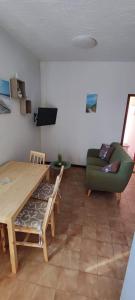 salon ze stołem i zieloną kanapą w obiekcie Apartments Berny w mieście Sveti Vid-Miholjice