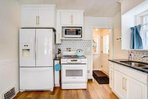 uma cozinha branca com um frigorífico e um lavatório em Charming Minneapolis Home Less Than 1 Mi to Lakes! em Minneapolis