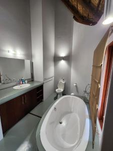 een badkamer met een groot wit bad en een wastafel bij Milkwood Safari Lodge in Warmbaths