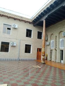 a large brick building with a pole in front of it at Hotel Sohibqiron Boutique in Bukhara