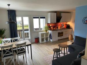 a kitchen and living room with a table and chairs at Spring Inn Apartments in Meiringen