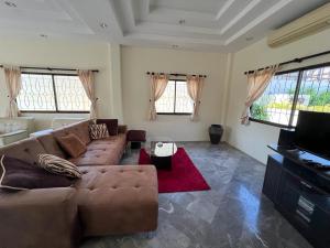 a living room with a couch and a television at Dragon Dream 1 D6 Hua Hin with Pool in Cha Am