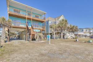 a large building with palm trees in front of it at Life is Good in Oak Island